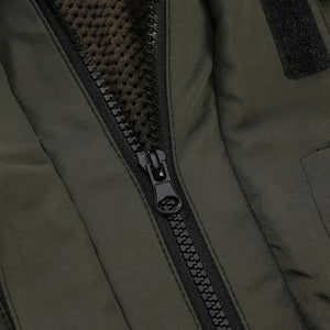 Close-up of a zipper on a green jacket with a textured inner lining.