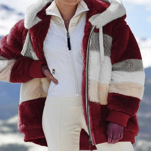 Person wearing a red and white fur-lined coat with a mountainous background