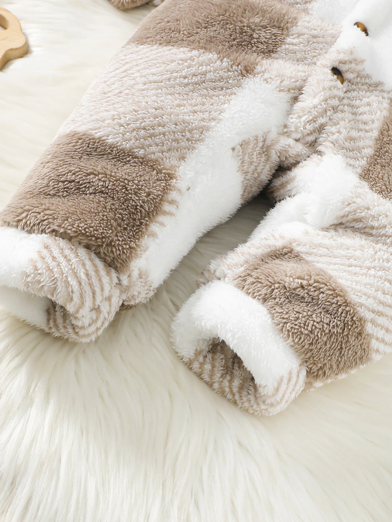 Pair of fluffy socks with brown and white pattern on a soft surface