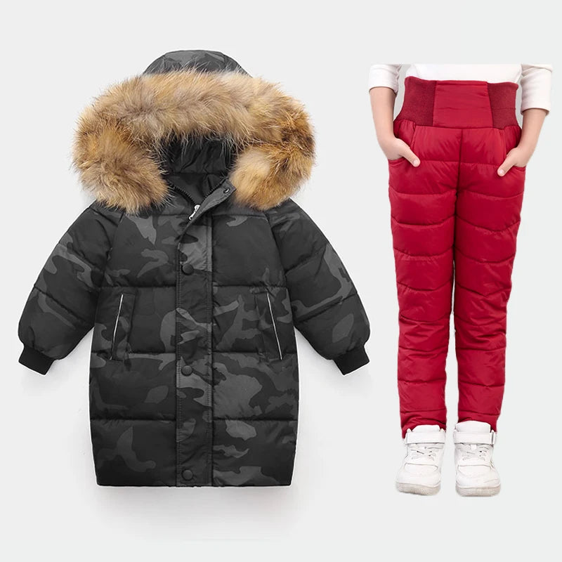 Black camouflage puffer coat with fur hood and red puffer pants on a white background