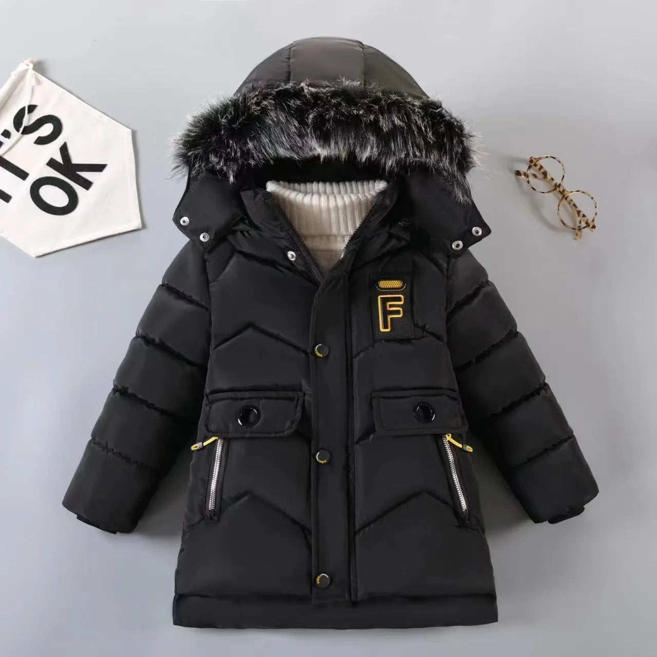 Black winter jacket with fur hood on a gray background