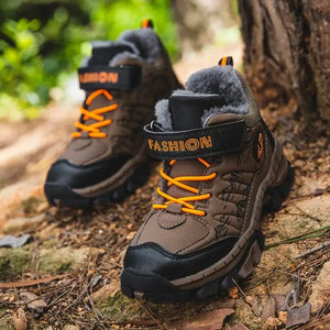 Brown hiking boots with orange laces on a natural background