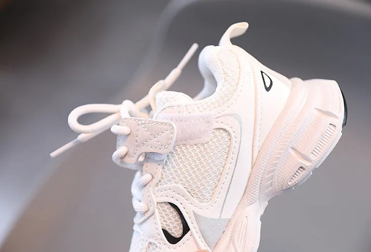 White sneaker with black logo on a gray background