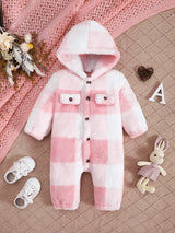 Pink and white checkered baby romper with a hood on a textured pink surface.