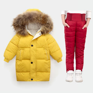 Yellow puffer coat with fur hood and red puffer pants on a white background