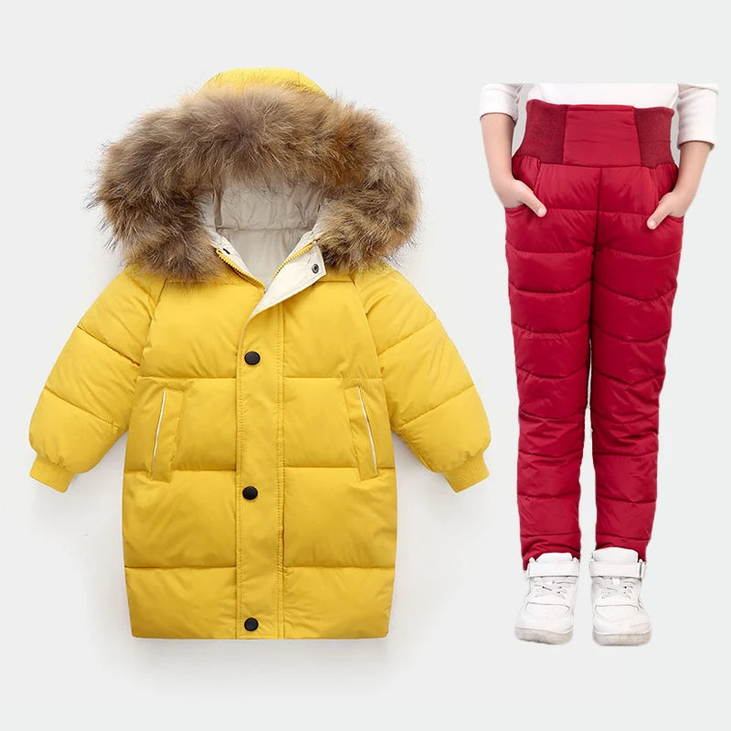 Yellow puffer coat with fur hood and red puffer pants on a white background