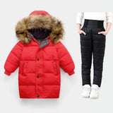Red puffer coat with fur hood and black puffer pants on a white background