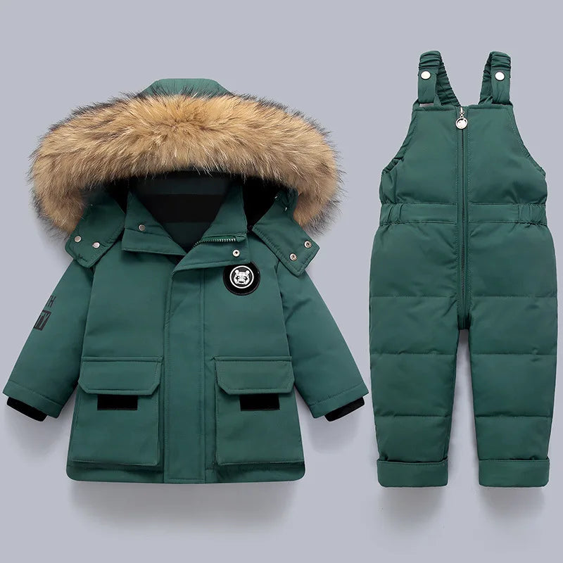 Green winter coat with fur hood and matching snowsuit on a light gray background