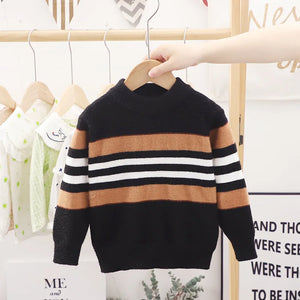 Children's striped sweater on a hanger against a white wall with text