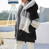 Person wearing a black, gray, and white patterned jacket outdoors.