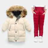 Beige puffer jacket with fur hood and red puffer pants on a white background