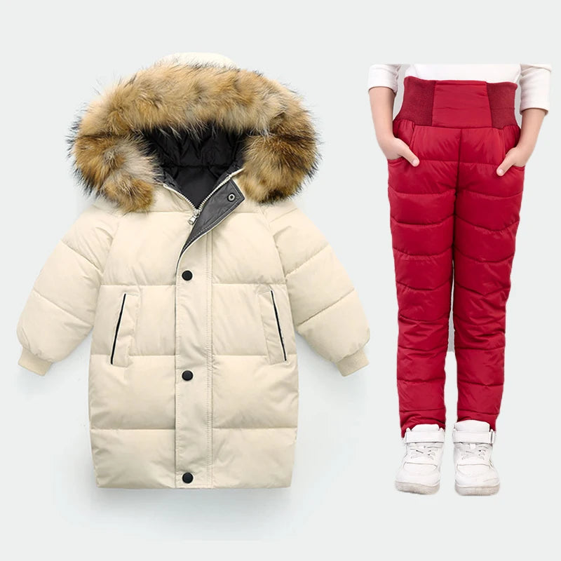 Beige puffer jacket with fur hood and red puffer pants on a white background