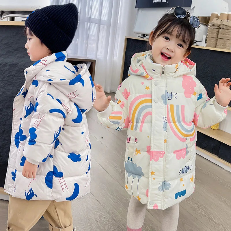 Two children wearing colorful winter jackets with cartoon designs indoors.