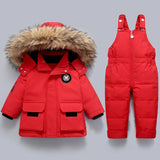 Red winter jacket with fur hood and red snowsuit on a gray background