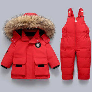 Red winter jacket with fur hood and red snowsuit on a gray background