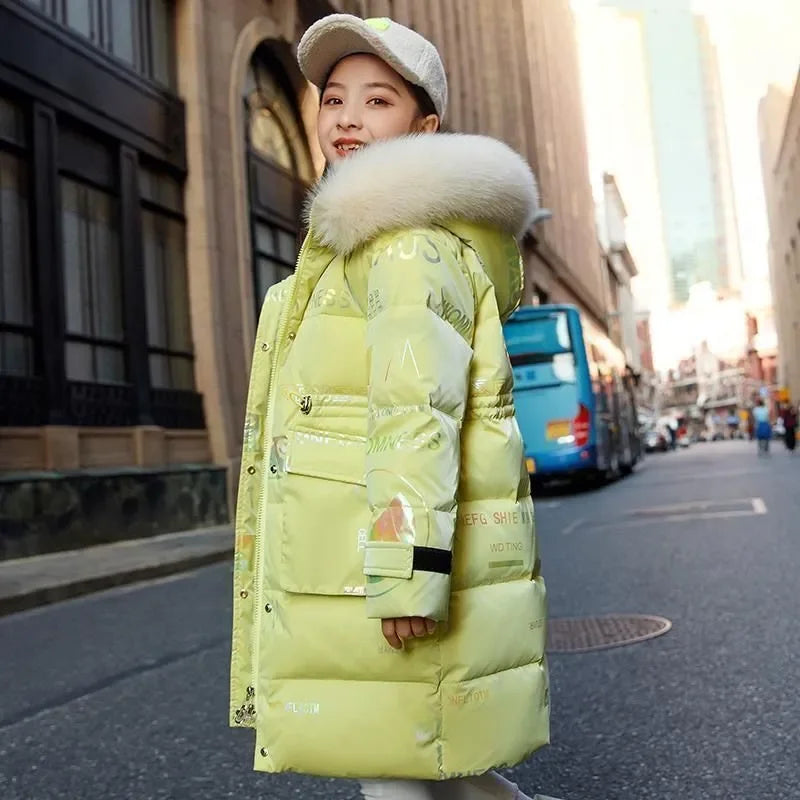 Person wearing a long yellow puffer coat with a fur-lined hood on a city street.