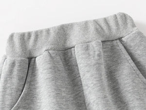 Close-up of gray sweatpants on a light gray background