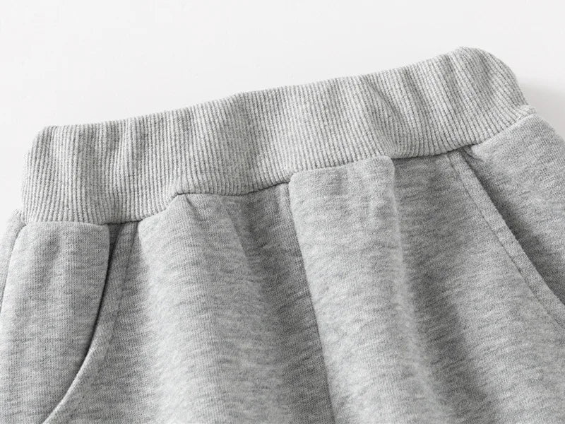 Close-up of gray sweatpants on a light gray background