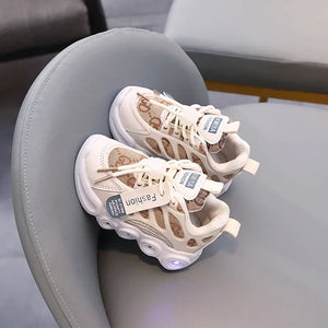 Pair of beige sneakers with LED lights on a gray chair