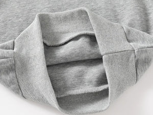 Close-up of a gray sweater with ribbed collar and cuffs on a light background