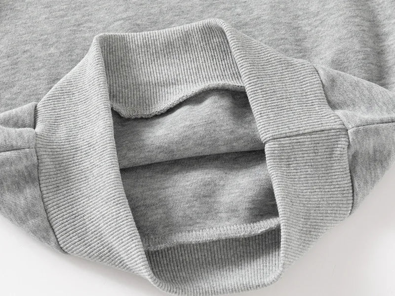 Close-up of a gray sweater with ribbed collar and cuffs on a light background