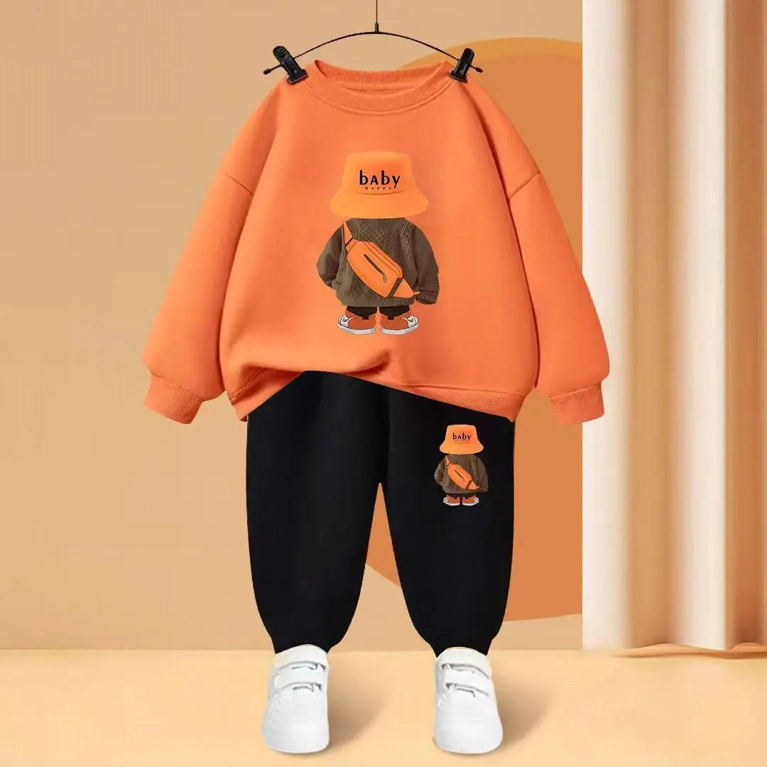 Orange sweatshirt with a cartoon character and black pants on a beige background