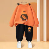 Orange sweatshirt with a cartoon character and black pants on a beige background