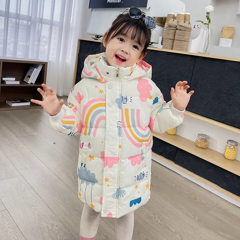 Child wearing a colorful raincoat with cartoon designs in a room.