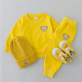 Yellow children's outfit with bear face design on a gray background