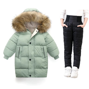 Green puffer coat with fur hood and black puffer pants on a white background