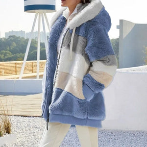 Person wearing a blue, gray, and beige sherpa jacket outdoors.