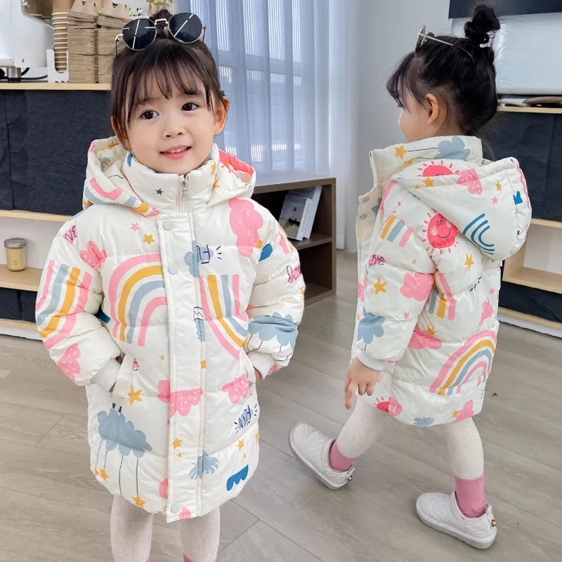 Two children wearing colorful raincoat with rainbow patterns indoors.