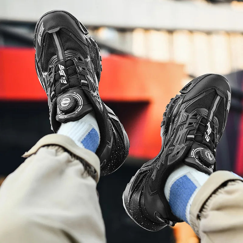 Black athletic shoes worn with beige pants and blue socks against a blurred indoor background