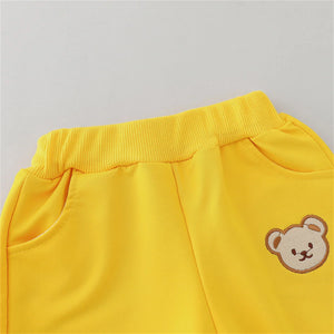 Yellow pants with a teddy bear patch on a gray background