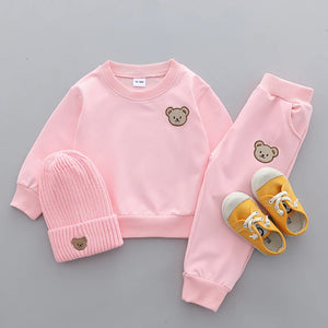 Pink children's outfit with bear embroidery on a gray background