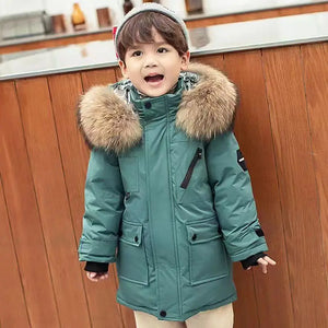 Child wearing a teal winter coat with a fur-lined hood in a kitchen setting
