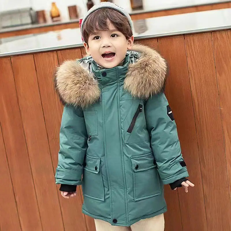 Child wearing a teal winter coat with a fur-lined hood in a kitchen setting