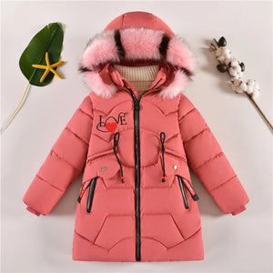 Pink children's puffer jacket with fur hood on a light gray background