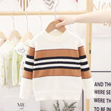 Children's striped sweater on a hanger with a blurred background