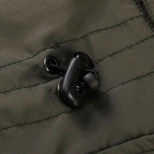 Close-up of a green jacket with a button