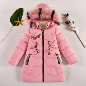 Pink children's coat with fur hood on a light gray background