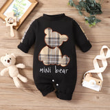 Black baby romper with plaid bear design and 'mini bear' text on a wooden surface with toys.
