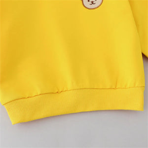 Yellow sweatshirt with a small round patch on a light gray background