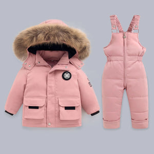 Pink winter coat with fur hood and matching snowsuit on a gray background