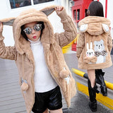 Beige plush coat with bunny designs worn by a person on a city street.