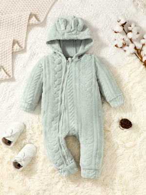 Light blue baby snowsuit with hood on a textured white surface