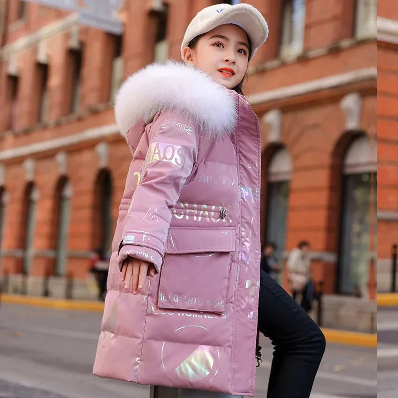 Person wearing a pink puffer jacket with a fur-lined hood in an urban setting.