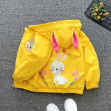 Yellow children's jacket with bunny design on a gray surface