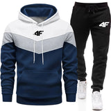 Color-blocked hoodie and black pants with a brand logo on a white background