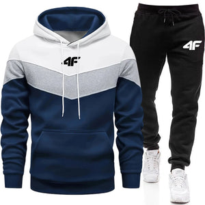 Color-blocked hoodie and black pants with a brand logo on a white background